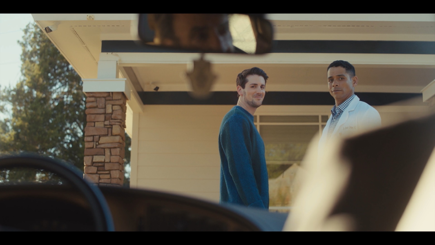 Nate and Dr. Daniel Green outside, seen through a car windshield